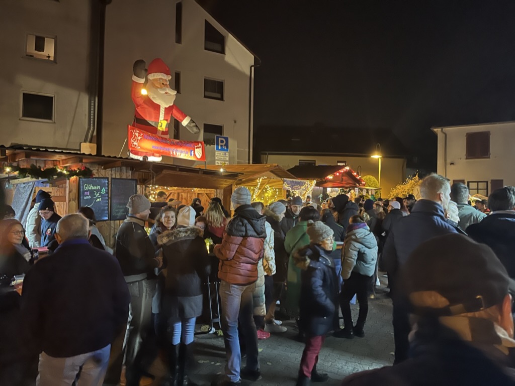 Viele Menschen stehen vor einer Verkaufshütte auf dem Dietzenbacher Weihnachtsmarkt.